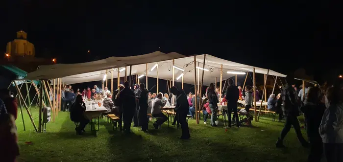 Repas sous une toile nomade éclairée, de nuit