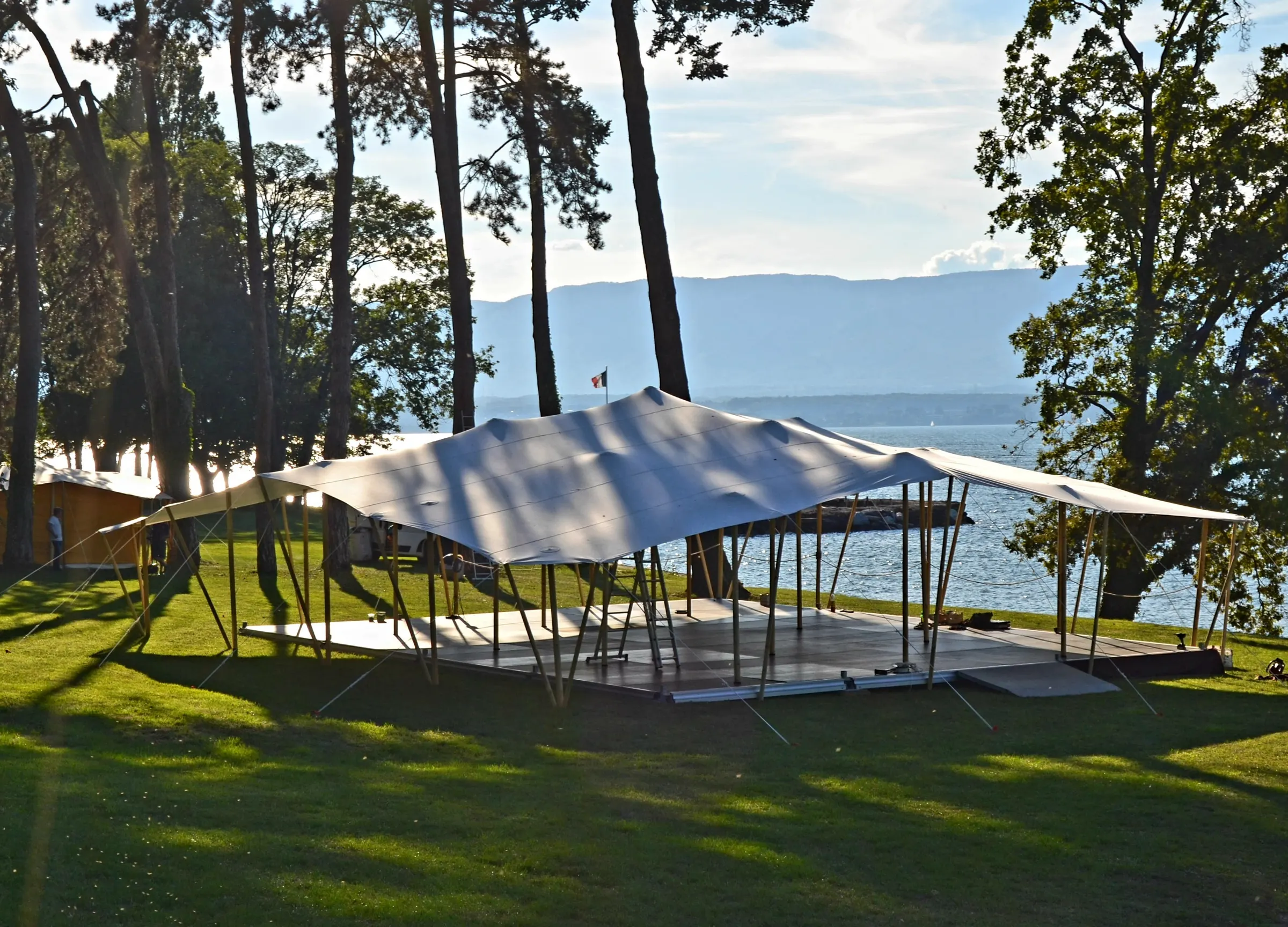 Toile nomade 14x14m installée au bord d’un lac, au coucher du soleil